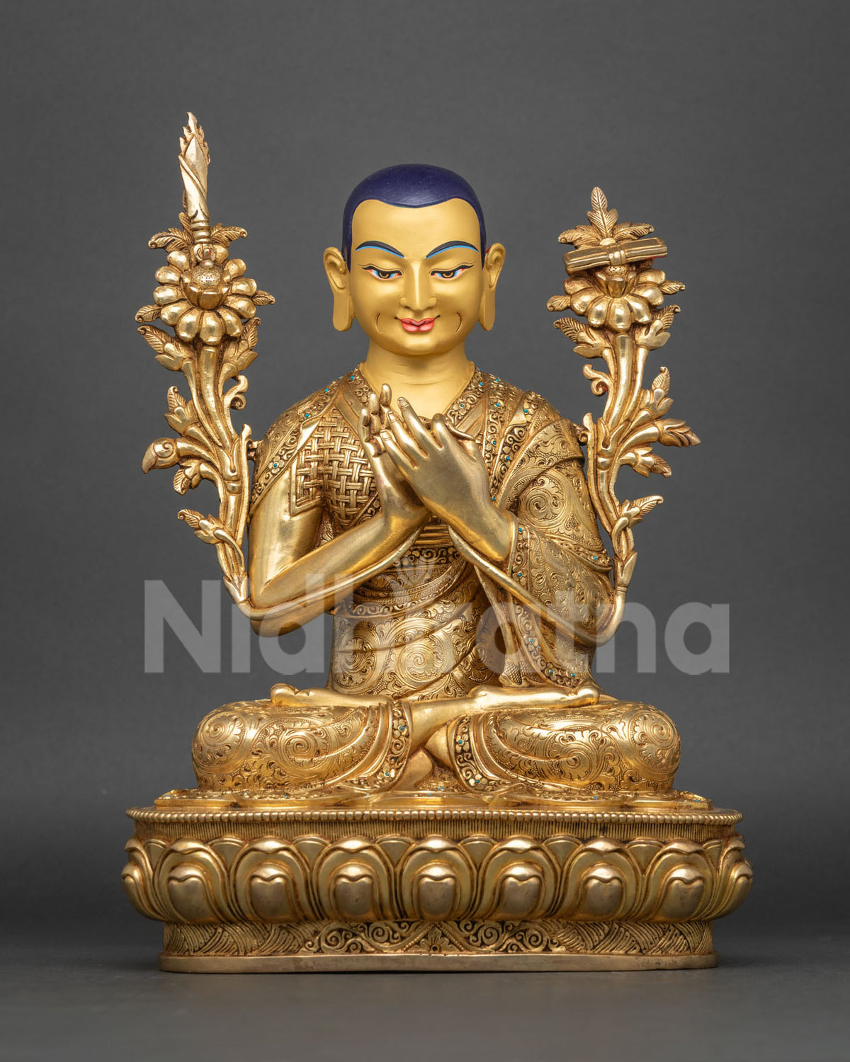 Front view of Je Tsongkhapa statue with gold-painted face and lotus stems holding sword and book