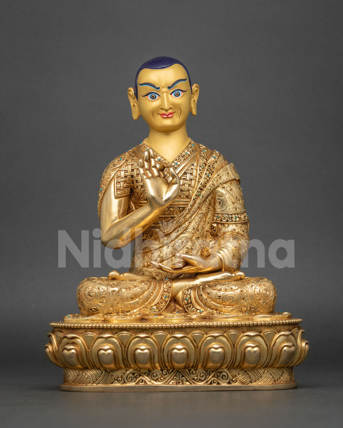 Front view of Khedrup Je statue with dark hair, gold-painted face and right hand raised in teaching pose