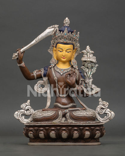 Front view of Manjushri statue, handcrafted in Nepal with oxidized silver finish gold painted face and semi precious stones