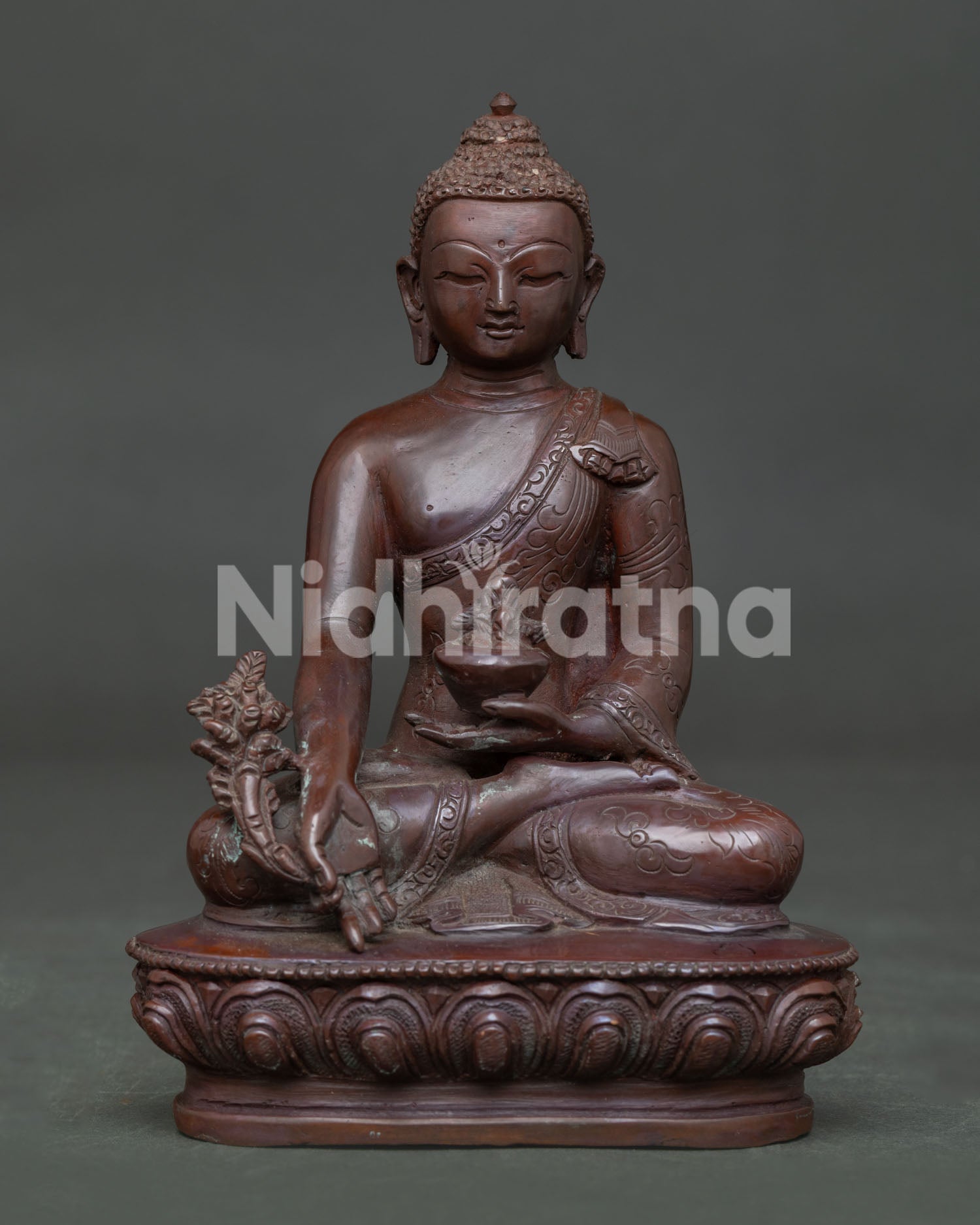 Front view of Medicine Buddha Statue handcrafted from oxidized copper on a lotus pedestal.