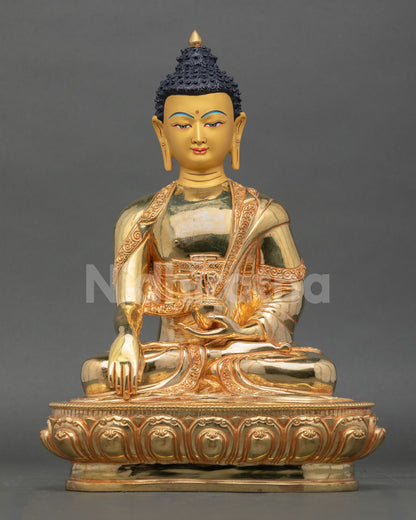 Front view of Shakyamuni Buddha statue handmade in copper with gold gilding and serene gold painted face seated on lotus pedestal