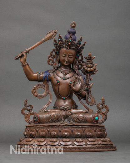 Front view of oxidized Manjushri statue, handcrafted from Nepalese copper. 