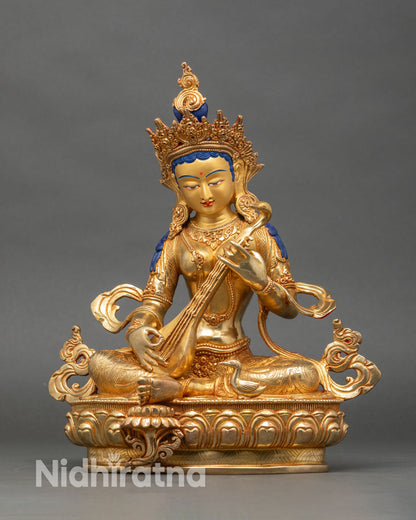 Front view Saraswati statue, copper and gold fire-gilded Hindu goddess with veena