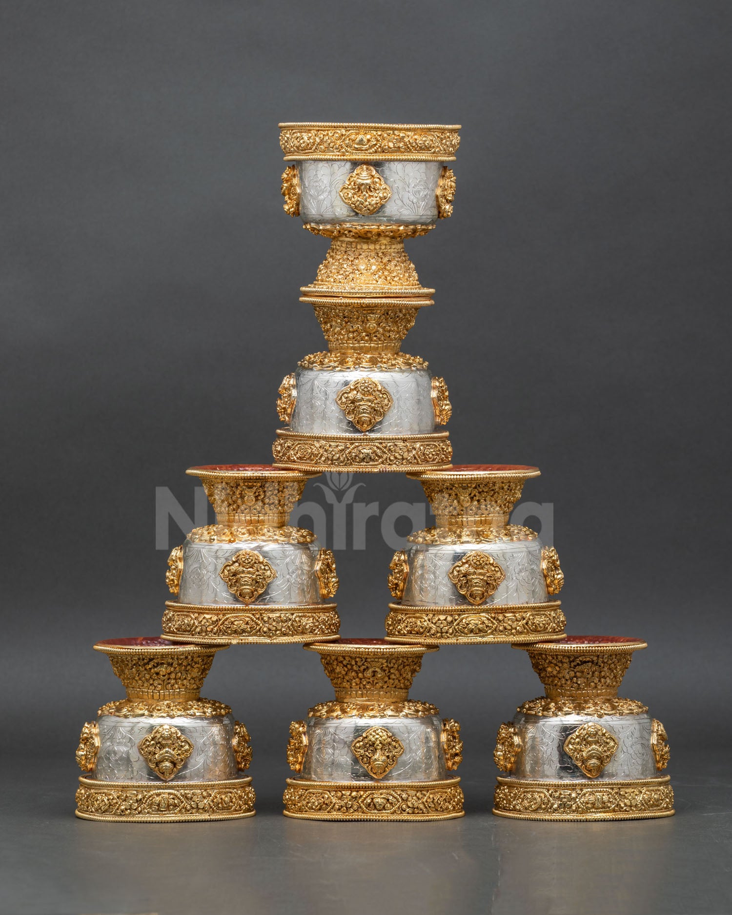 Front view set of seven water offering bowls handcrafted in copper with gold and silver plated finish featuring engraved auspicious Buddhist symbols