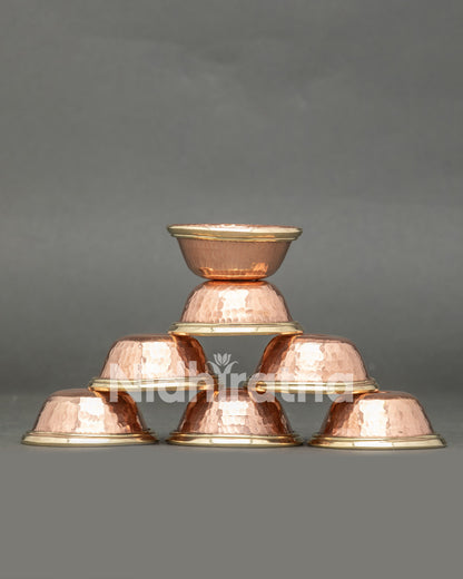 Front view seven handcrafted copper water offering bowls from Patan Nepal