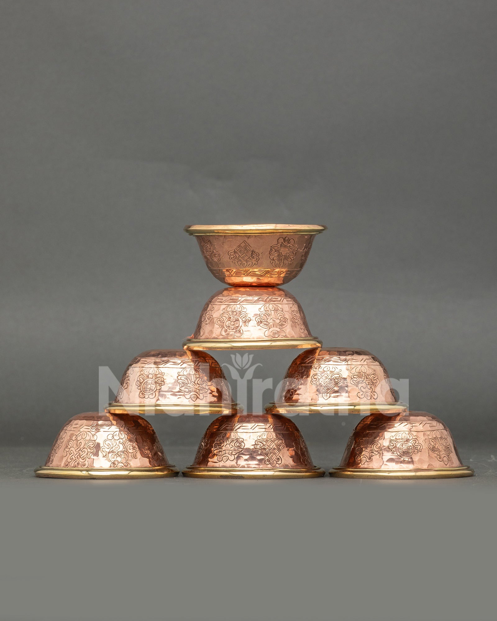 Front view seven water offering bowls handcrafted copper engraved with Buddhist symbolsc