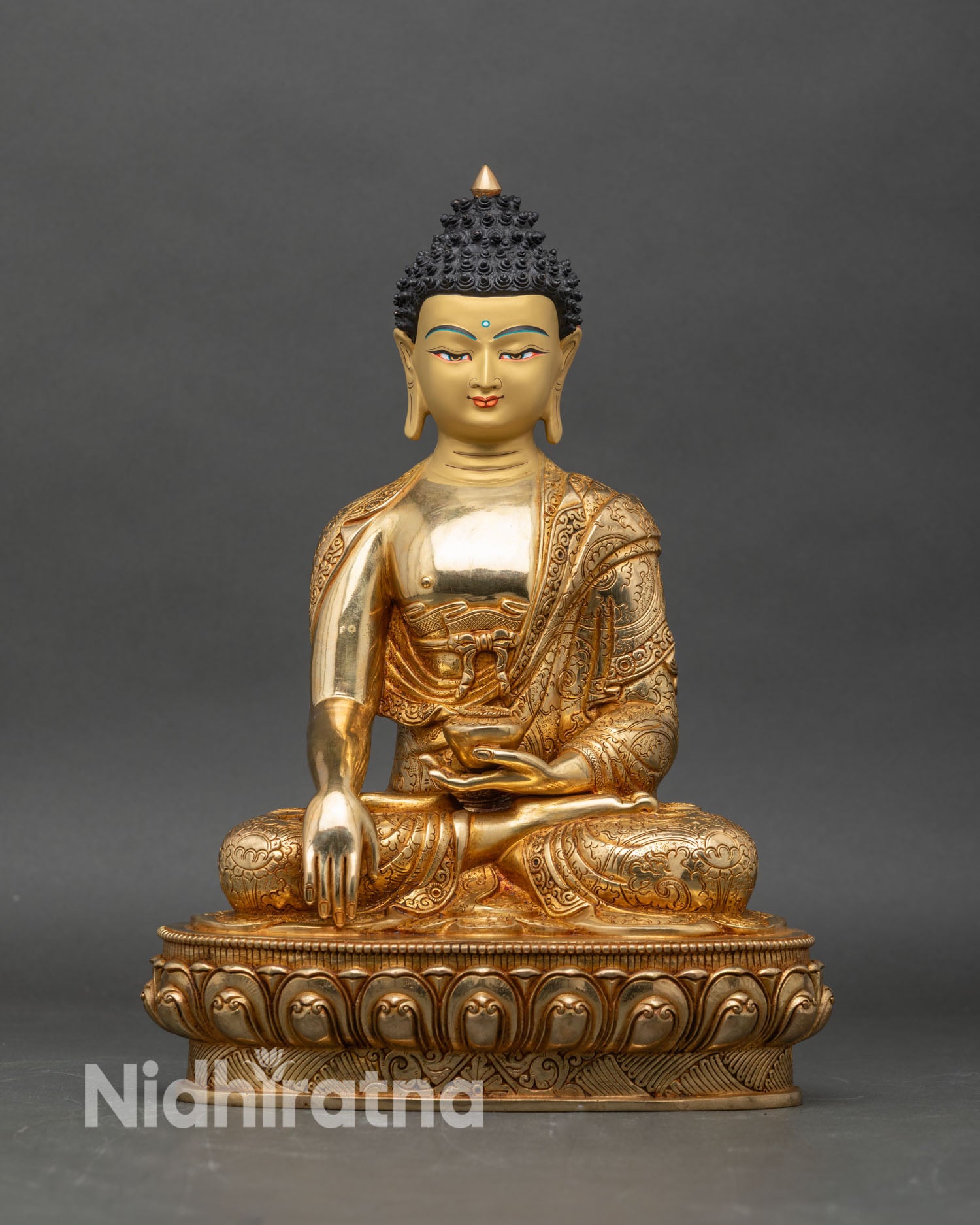Front view of Shakyamuni Buddha statue with gold gilding and lotus pedestal for meditation