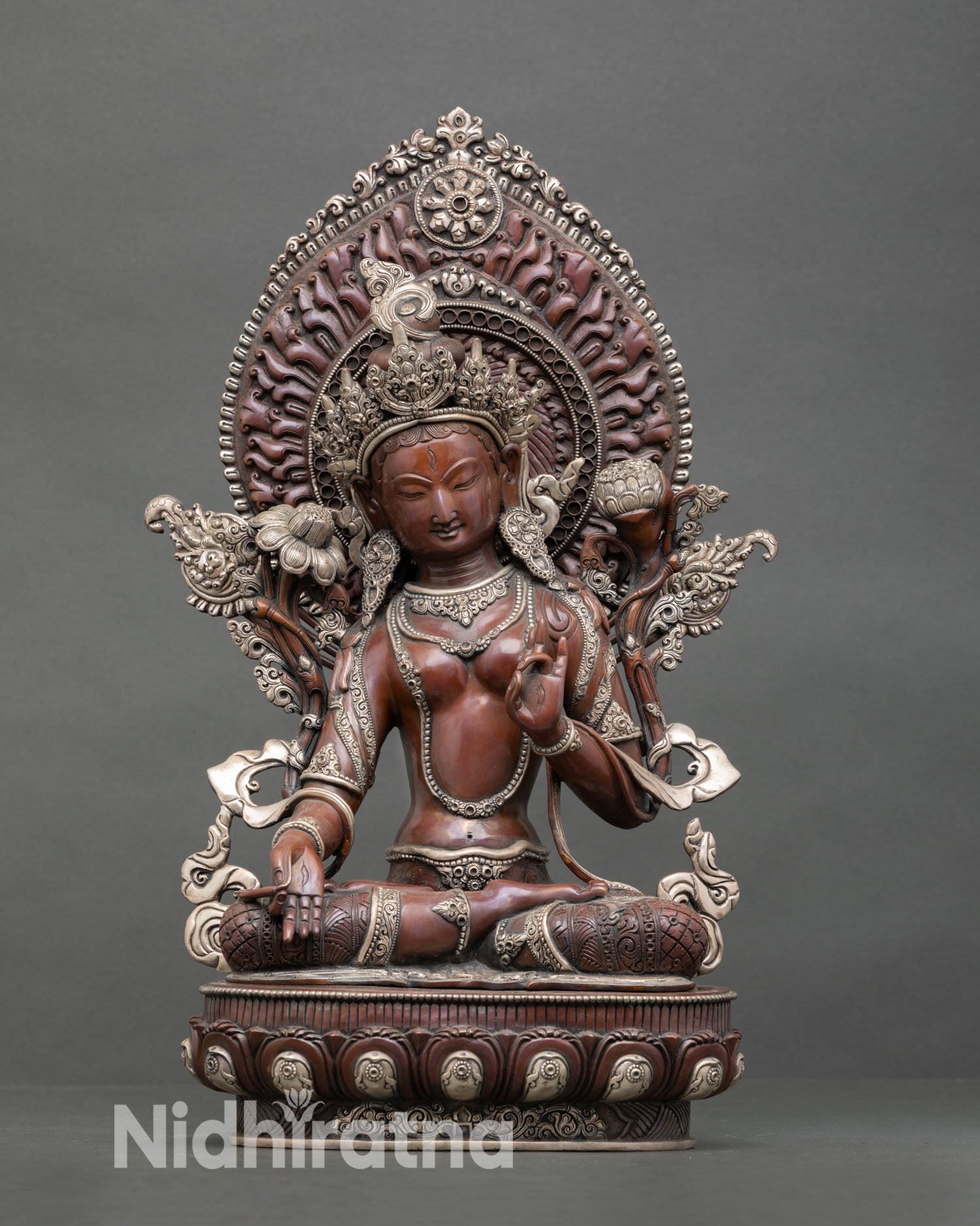 Front view of White Tara statue handcrafted in copper with oxidized silver plated finish seated on lotus pedestal with radiant halo and seven wisdom eyes for meditation altar decor