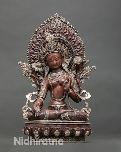 Front view of White Tara statue handcrafted in copper with oxidized silver plated finish seated on lotus pedestal with radiant halo and seven wisdom eyes for meditation altar decor