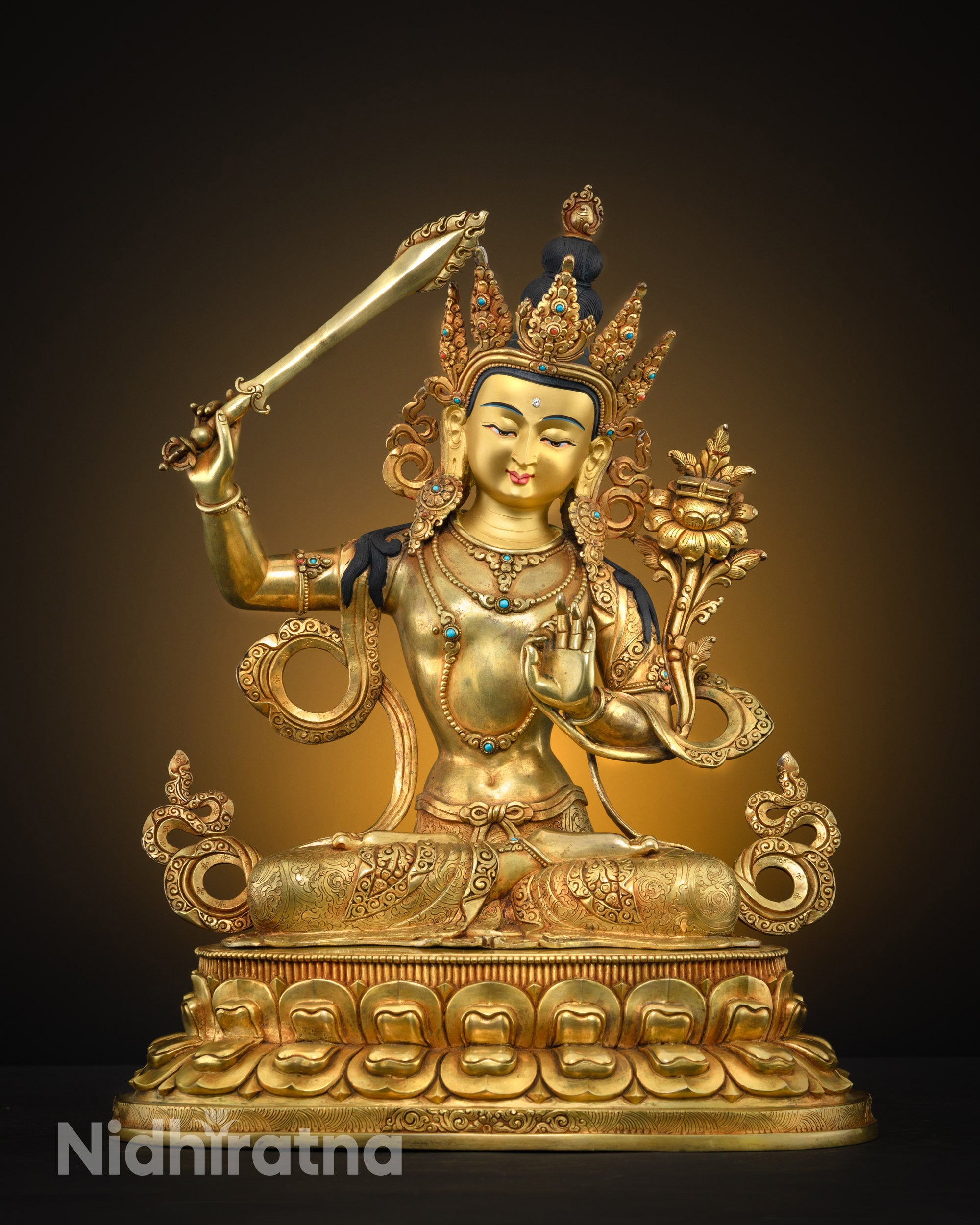 front view Manjushri statue seated on lotus with sword and hand mudra adorned with semi-precious stones