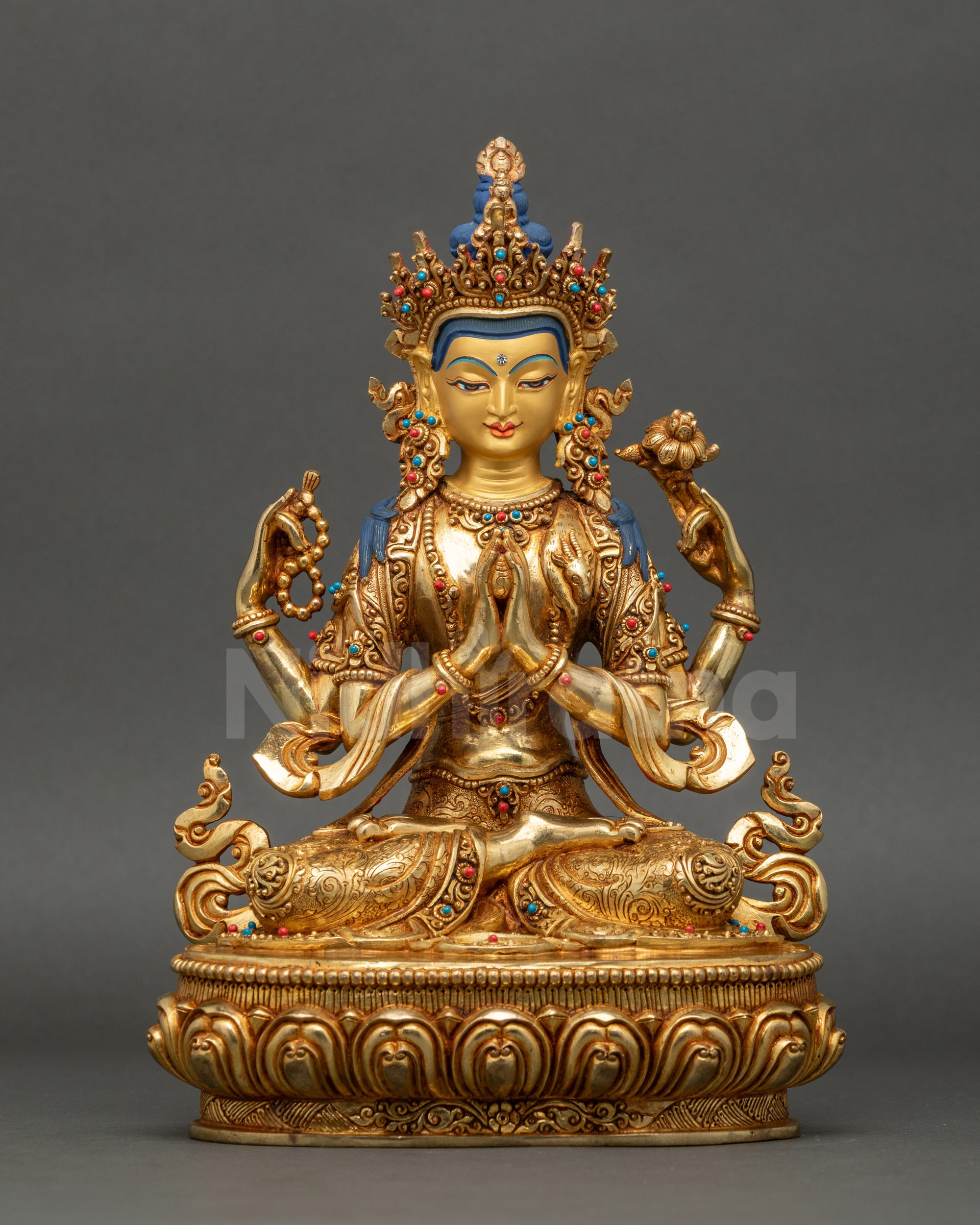 front view of Chenrezig statue seated on lotus base with gold gilding