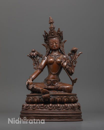 front view of dark oxidized green tara statue with lotus base and utpala flower detail