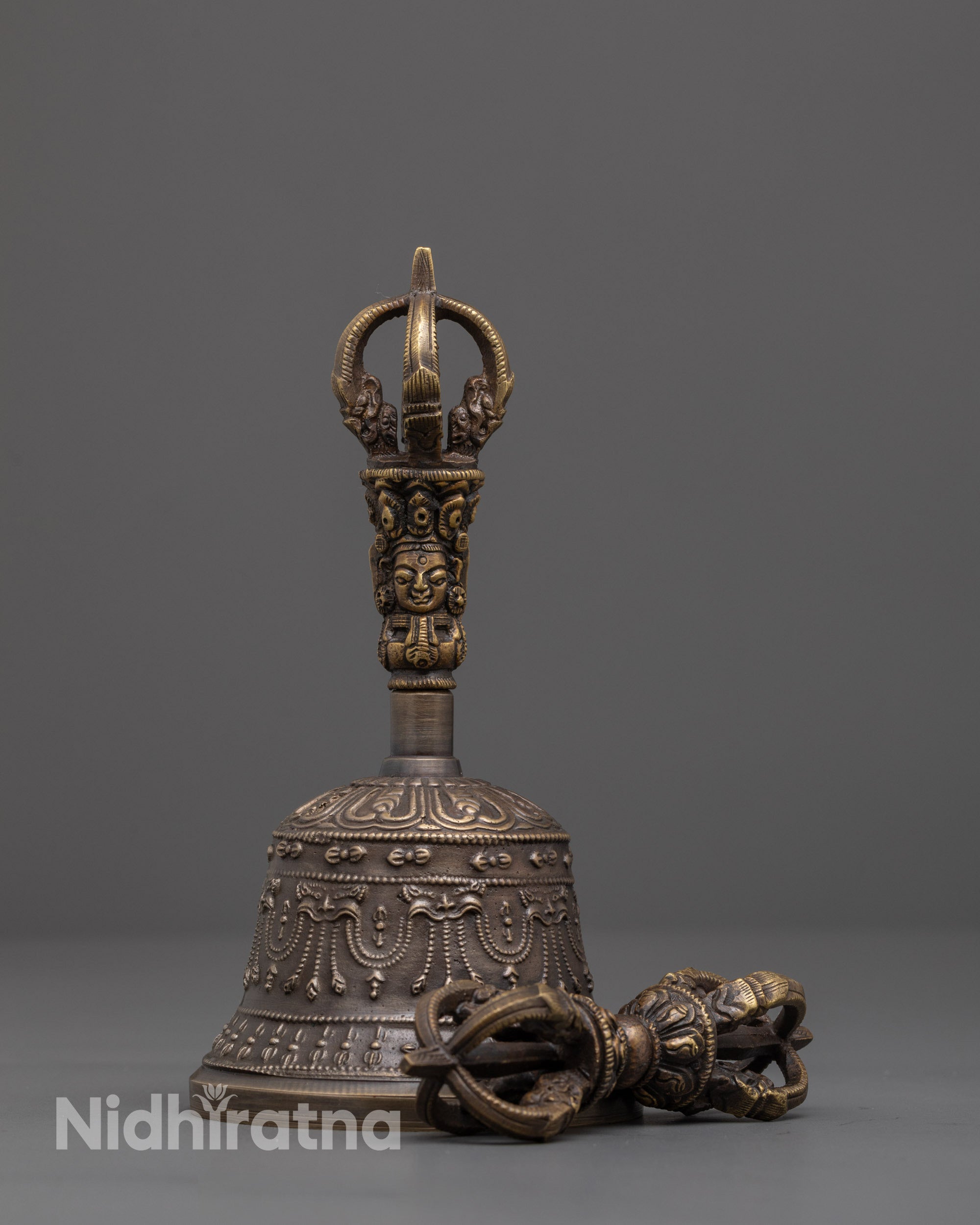 front view of handcrafted bronze vajra and bell set with brass handle deity design