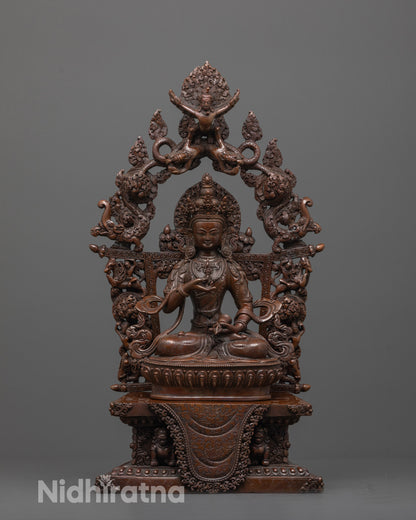 front view of oxidized vajrasattva statue seated on lotus and lion throne with carved halo