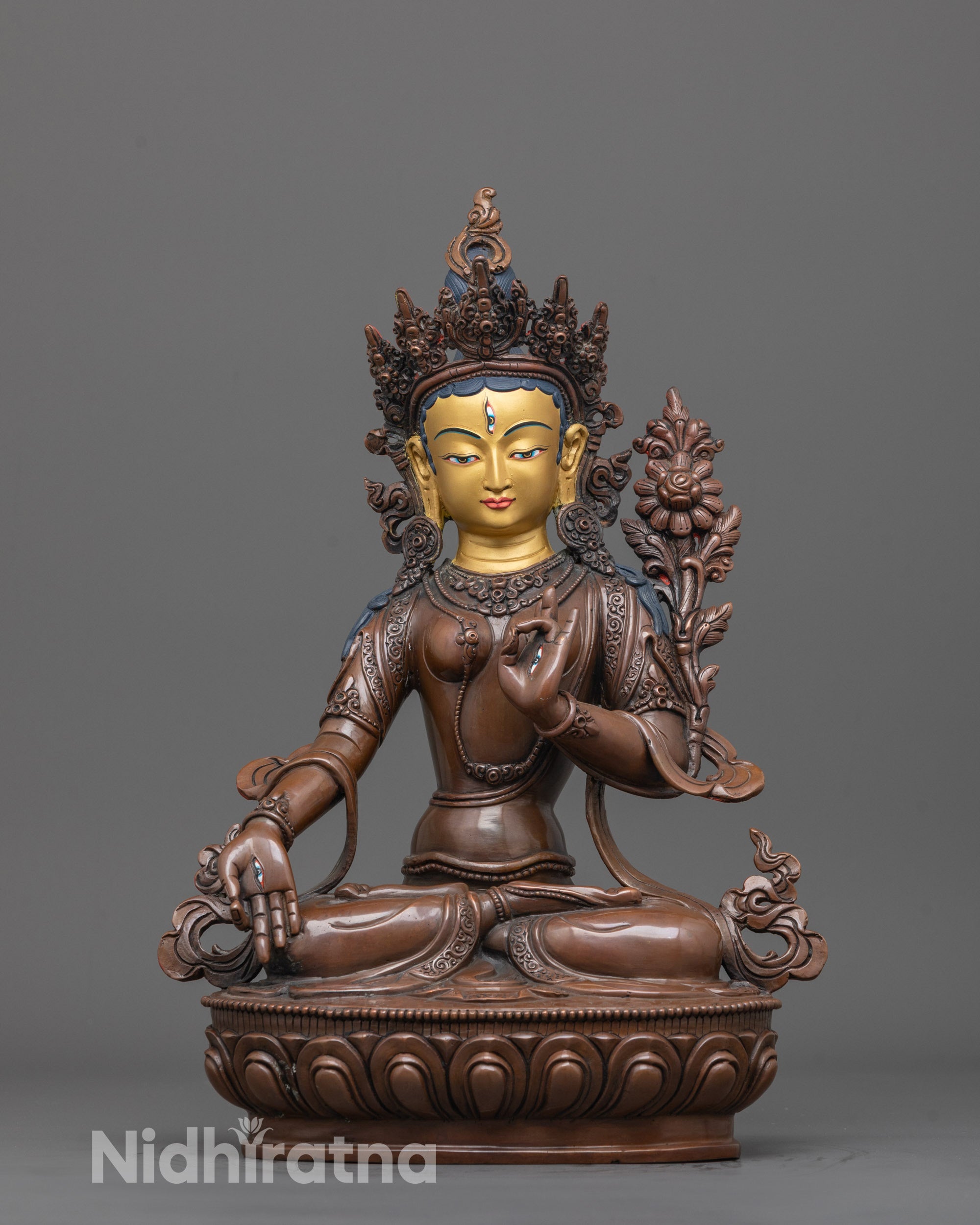 front view of oxidized white tara statue with gold face and seven eyes symbolizing wisdom