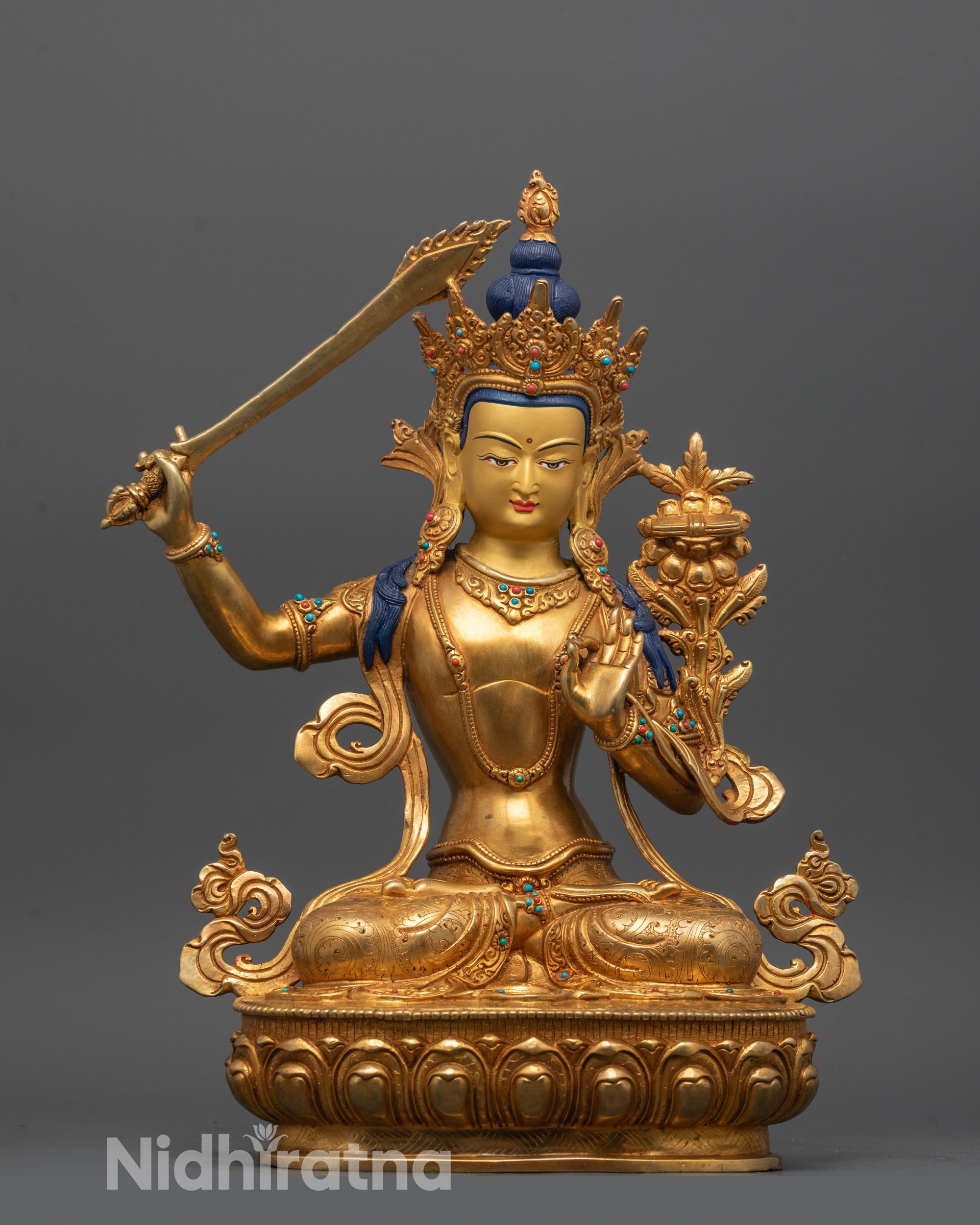 front view of traditional manjushri statue with gold-gilded face and fire-gilded copper body