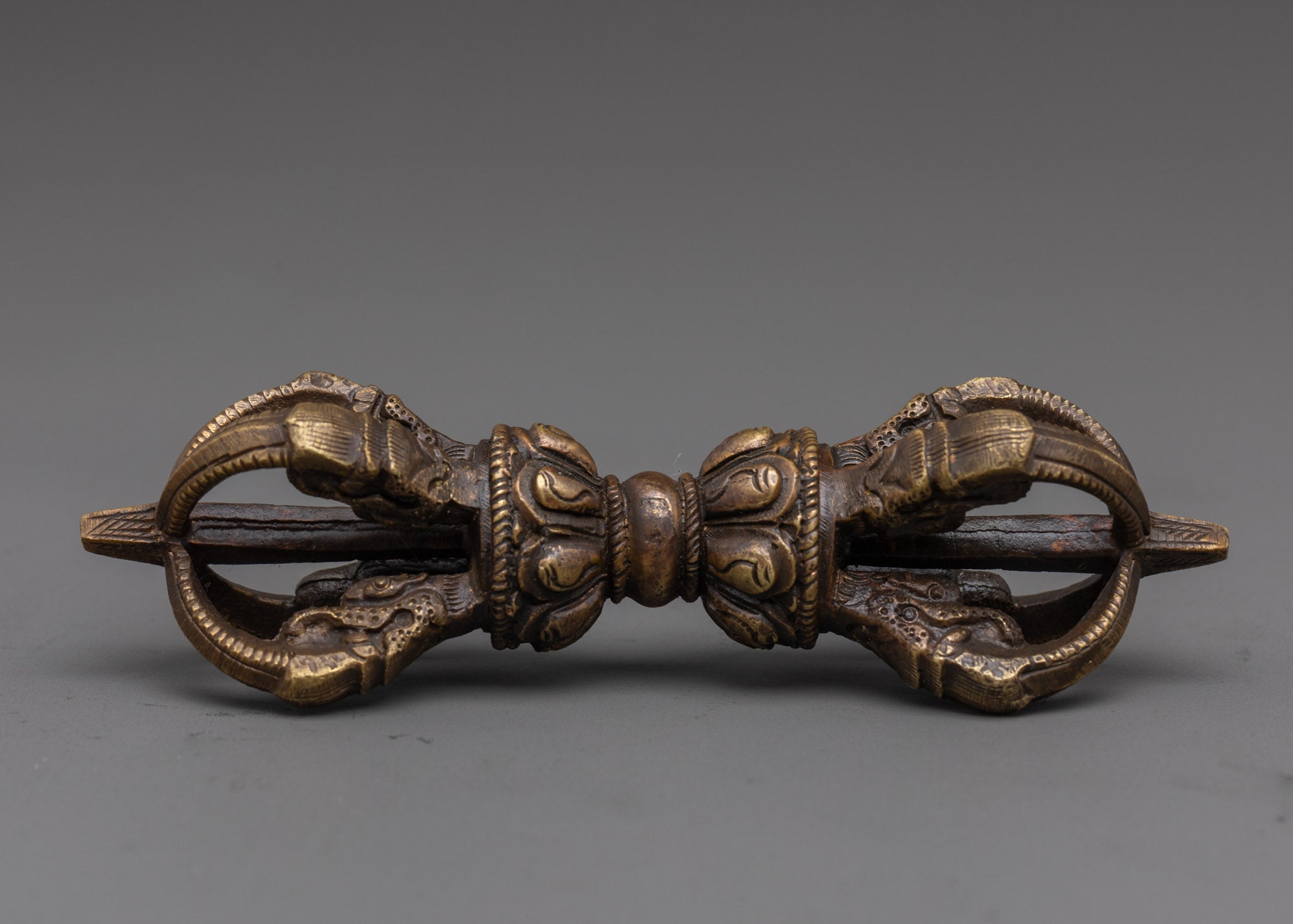 full view of handcrafted bronze vajra with detailed carvings for sacred tibetan rituals