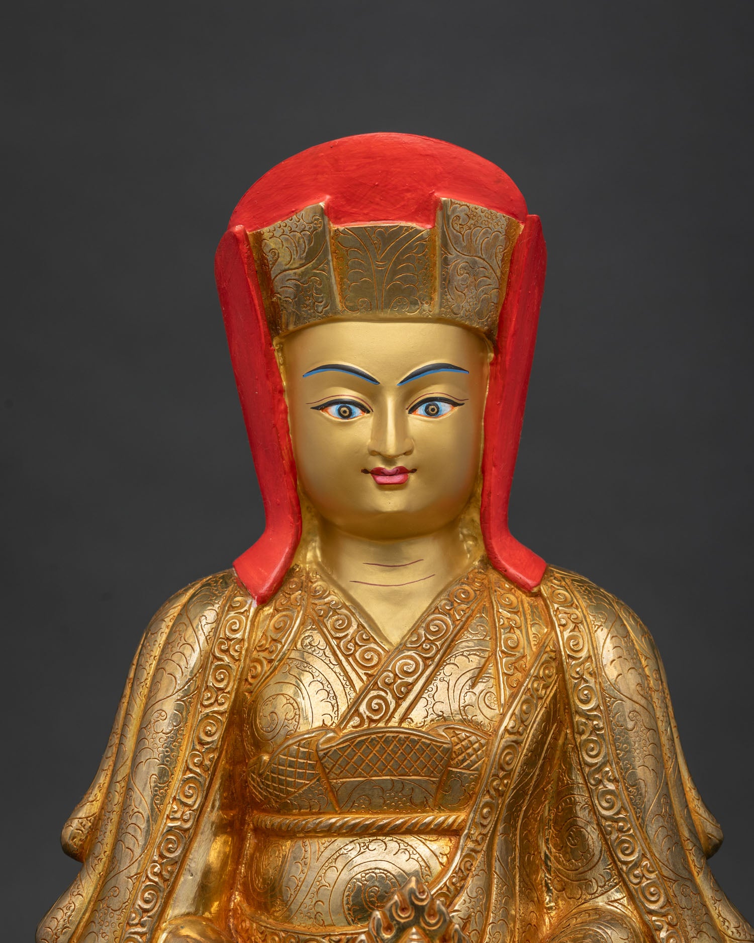 Gampopa statue seated in peaceful meditation wearing traditional scholar hat