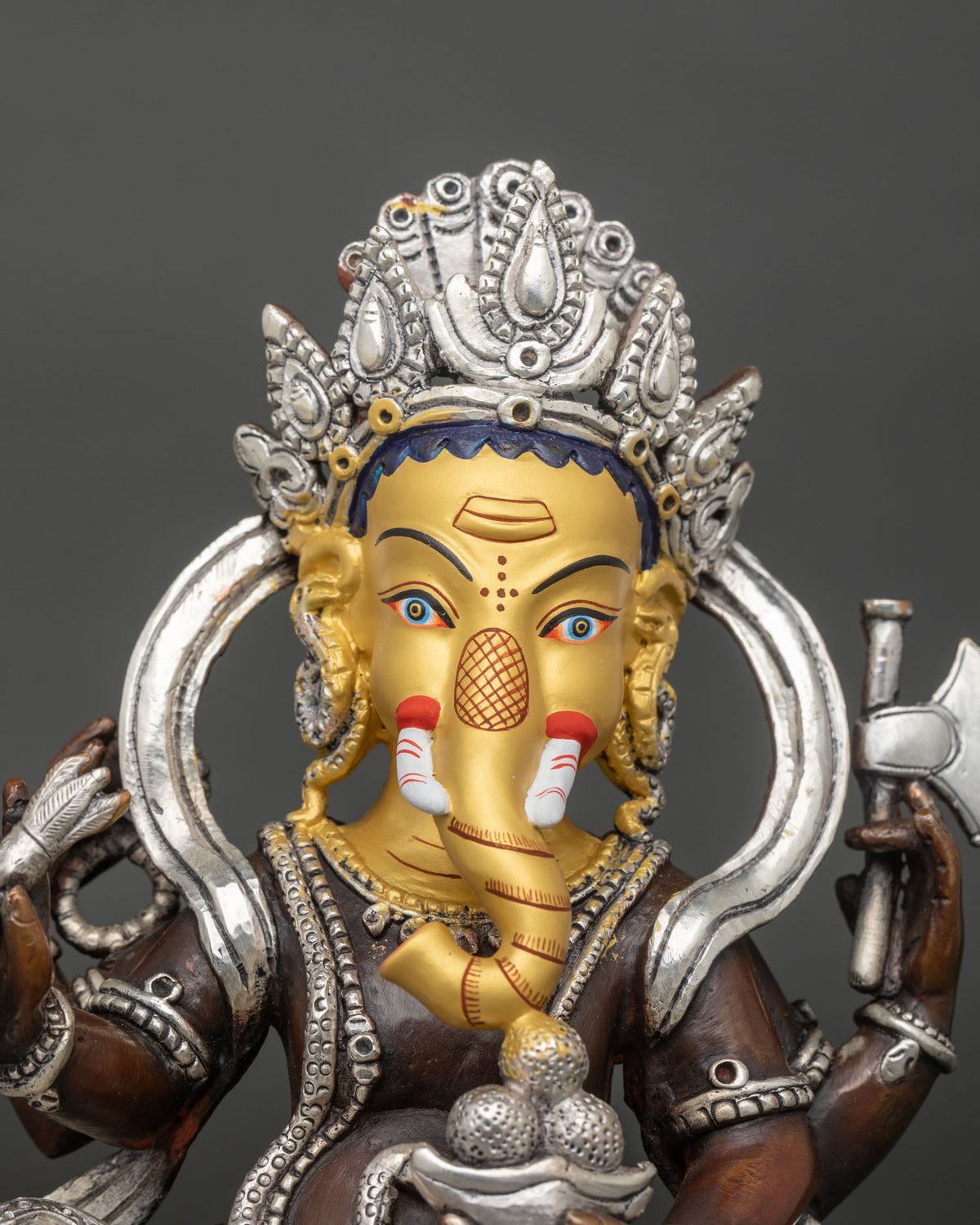 Ganesh statue close up 24K gold painted face intricate Newari craftsmanship sacred details.