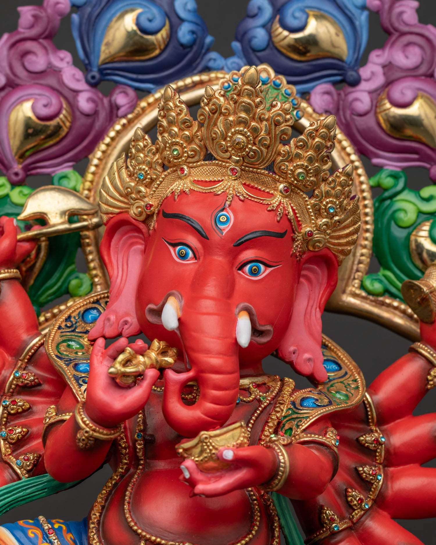 Ganesh statue front closeup showing third eye jeweled crown and intricate details.