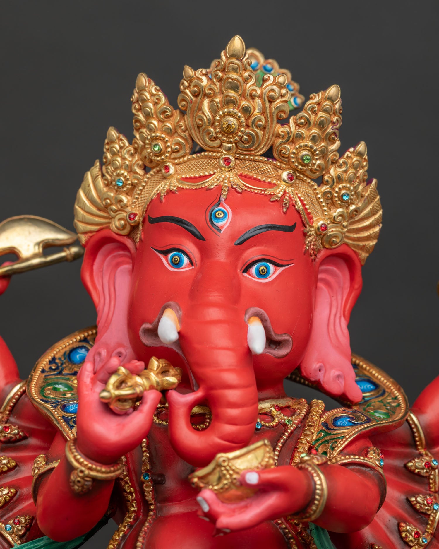 Ganesh statue side face closeup showing third eye crown and detailed facial features.