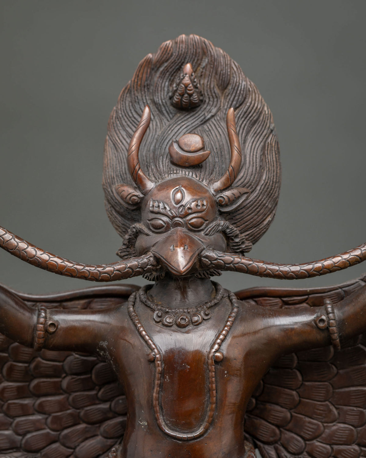 Garuda statue featuring a commanding expression intricate halo and finely carved feathers.