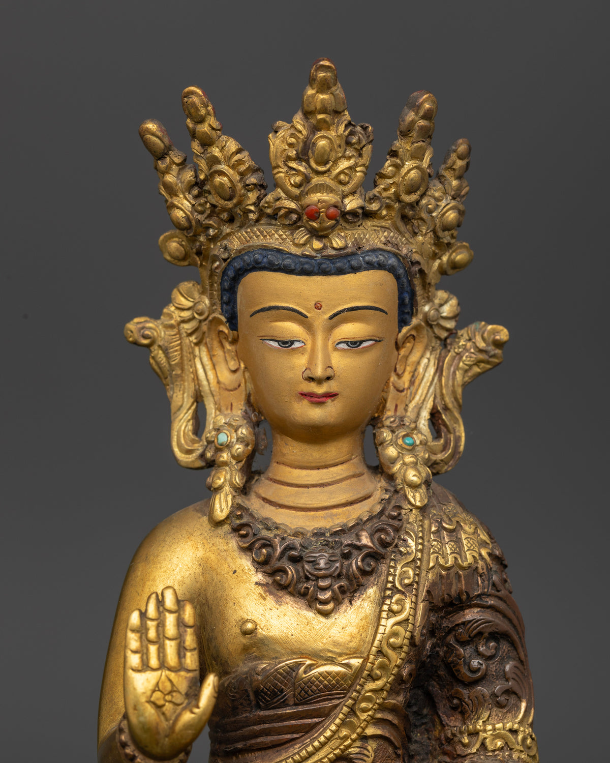 Dipankara Buddha sculpture wearing an ornate crown, gold-painted face and flowing robes with Abhaya Mudra and Varada Mudra hand gestures