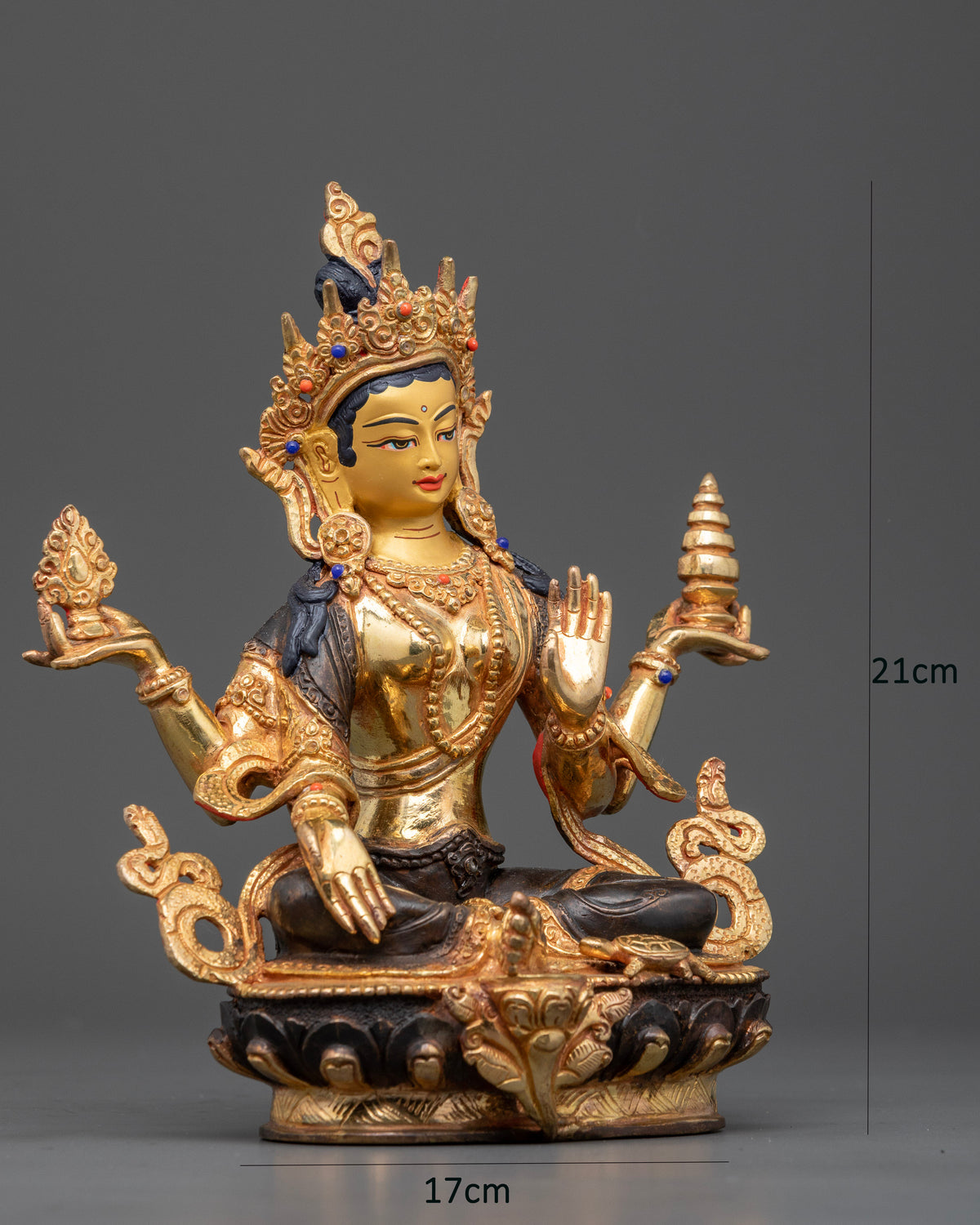 Goddess Laxmi seated on a lotus throne with four arms, gold-painted face, and semi-precious stones