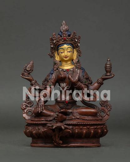 Goddess Laxmi statue seated on lotus flower holding golden mirror and sacred vase.