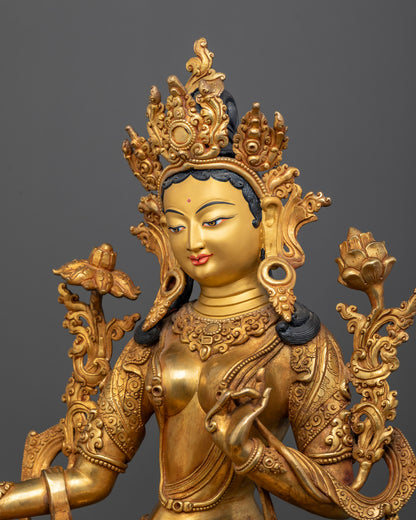 Gold gilded Green Tara Buddhist statue with elaborate earrings necklaces and garment.