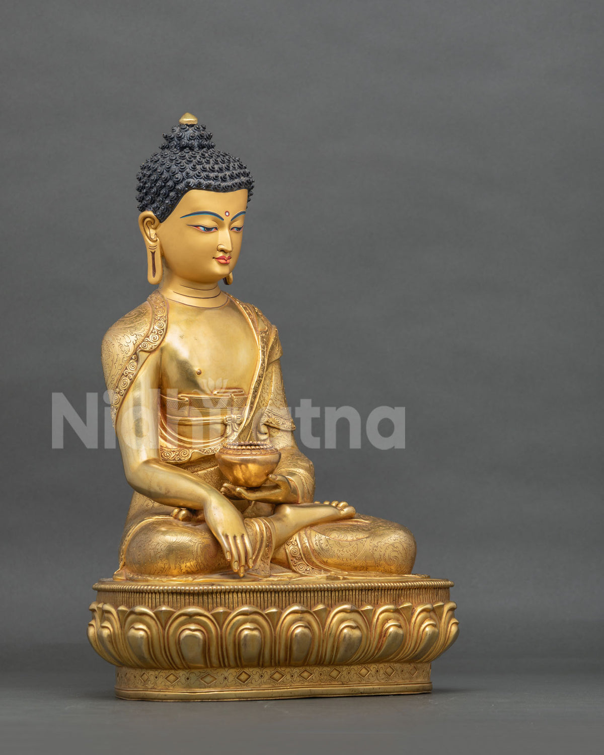 Gold fire-gilded Shakyamuni Buddha statue side view in earth-touching mudra holding patra bowl