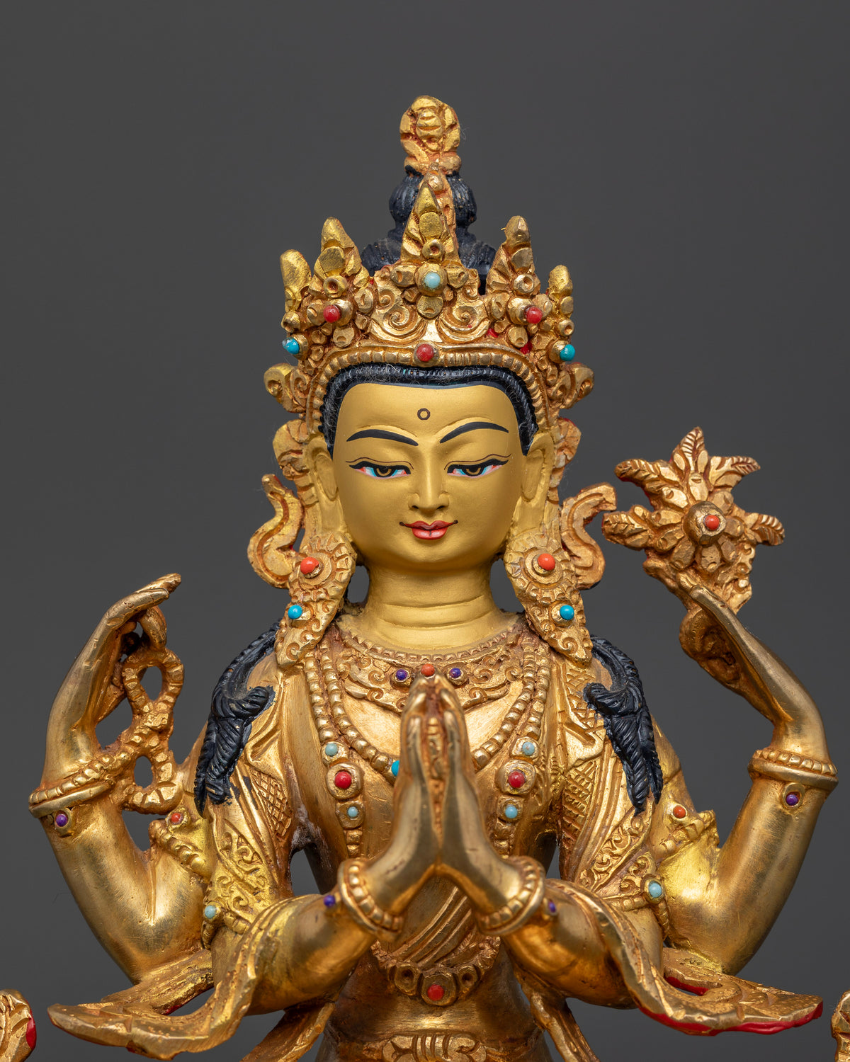 Gold-gilded Chenrezig Buddhist sculpture with a gold-painted face and intricate ornamental carvings