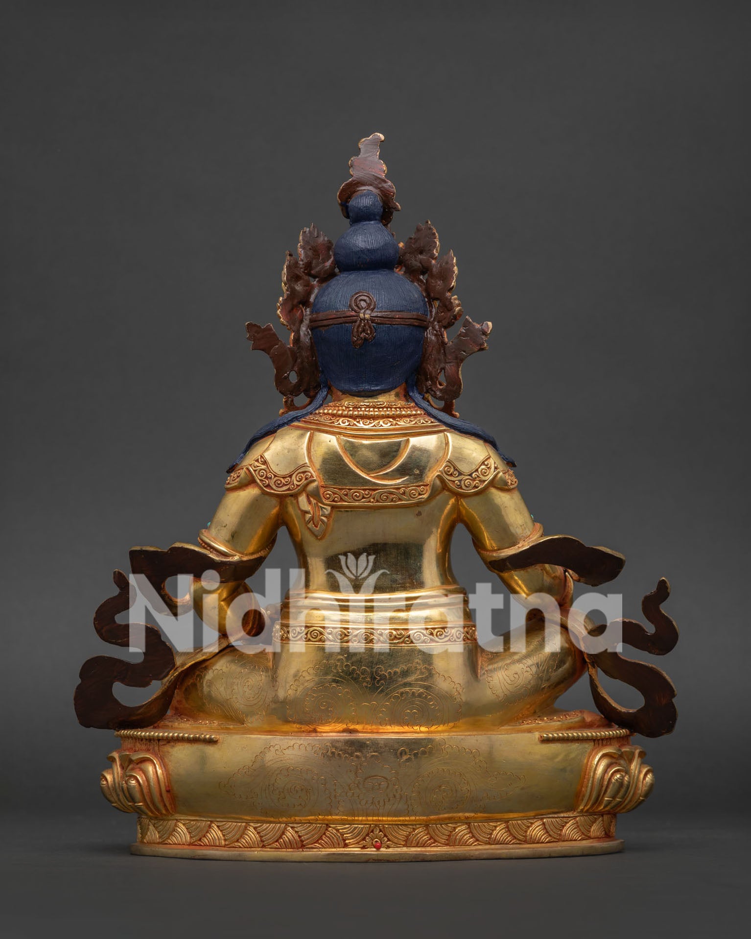 Gold gilded Dzambhala Buddhist statue seated on lotus pedestal for altar and meditation