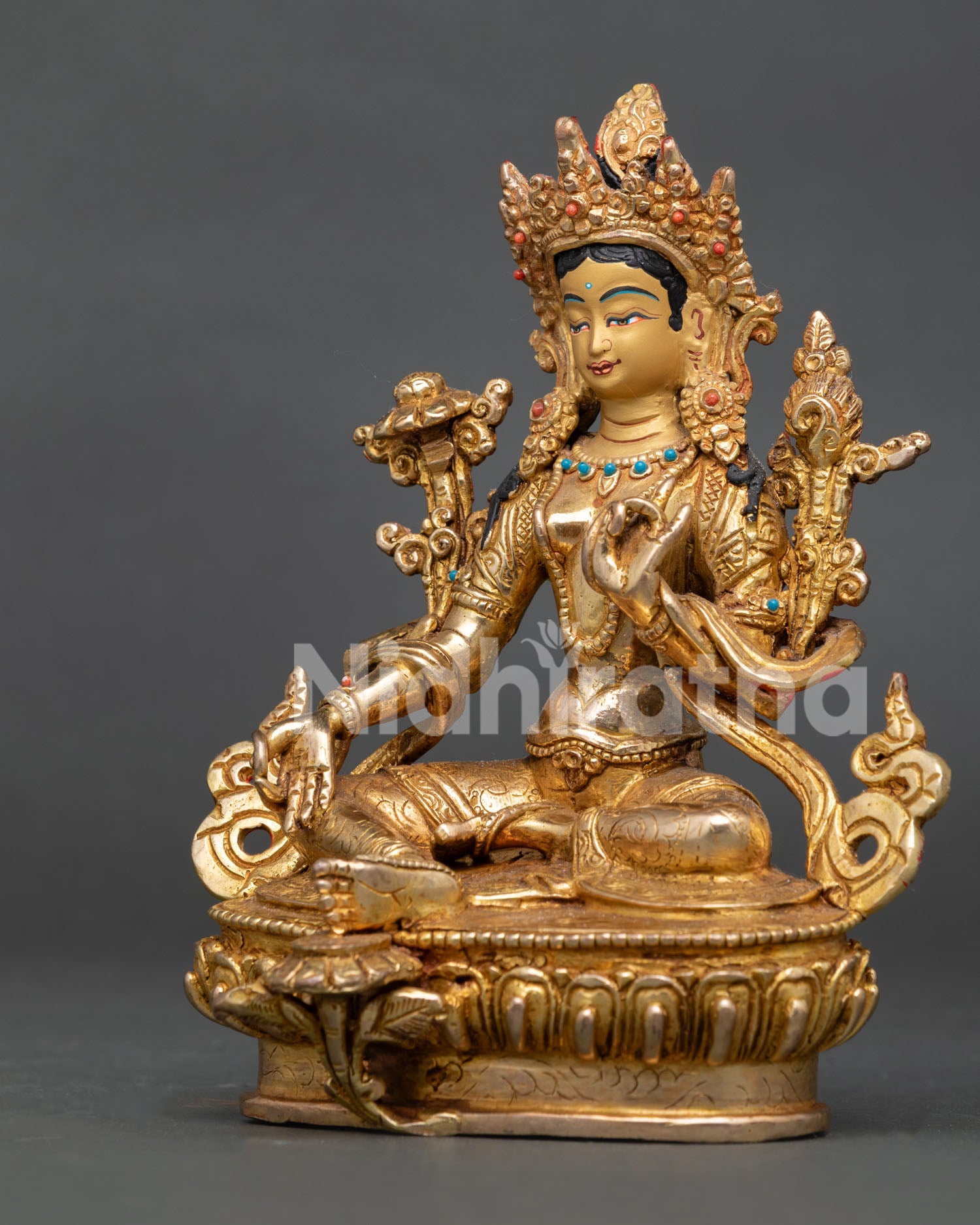 Gold-gilded Green Tara Buddhist sculpture with gemstone embellishments in Nepalese art.