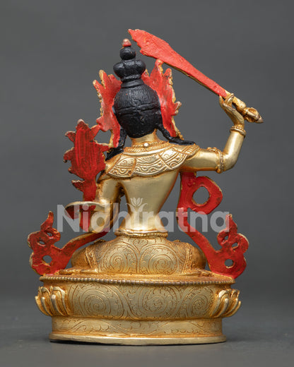 Gold gilded manjushri buddhist sculpture with turquoise coral and sacred symbols.