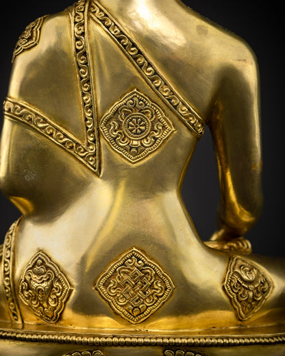 Gold-gilded Shakyamuni Buddha sculpture with a finely detailed gold-painted face and a monastic robe engraved with the Eight Auspicious Symbols.