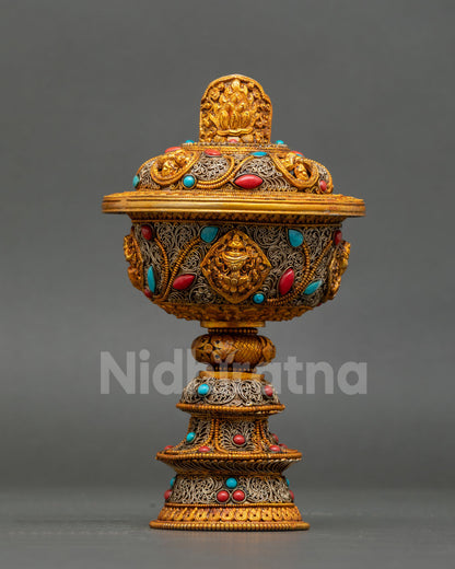 Gold-gilded Tibetan butter lamp body featuring Kirtimukha face medallion surrounded by silver filigree arabesques