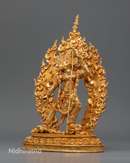 Gold gilded Vajrayogini sculpture standing on a lotus pedestal above subdued figures, symbolizing wisdom and spiritual liberation