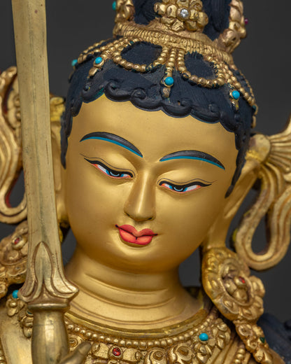 Gold-painted face of Manjushri Statue with jeweled crown and serene expression