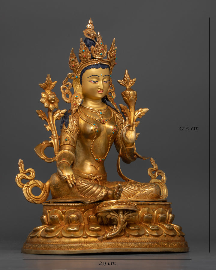 side profile of gold plated green tara statue adorned with gemstones