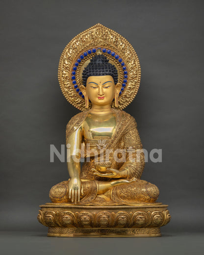 Golden Shakyamuni Buddha statue with ornate halo and lotus throne, front view