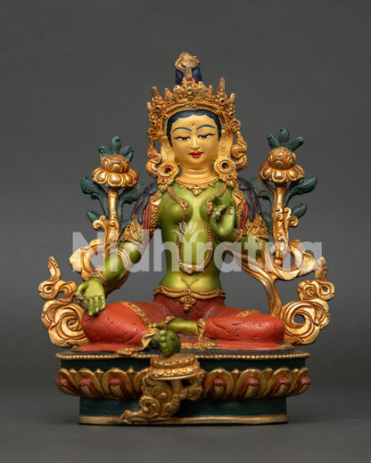 Green Tara bodhisattva statue seated gracefully on a lotus throne with right leg extended forward resting on a blooming lotus flower.