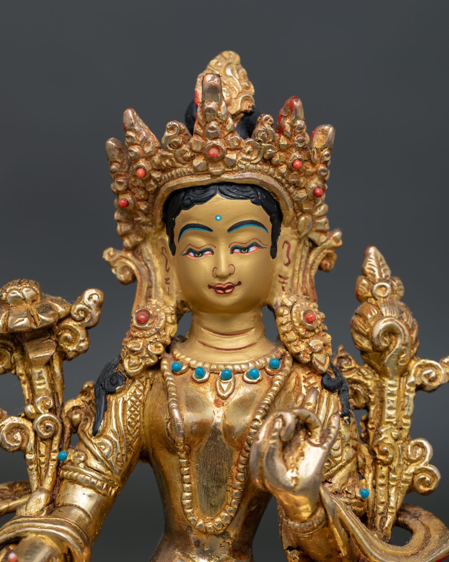 Green Tara Bodhisattva with gold-painted details and turquoise ornaments.