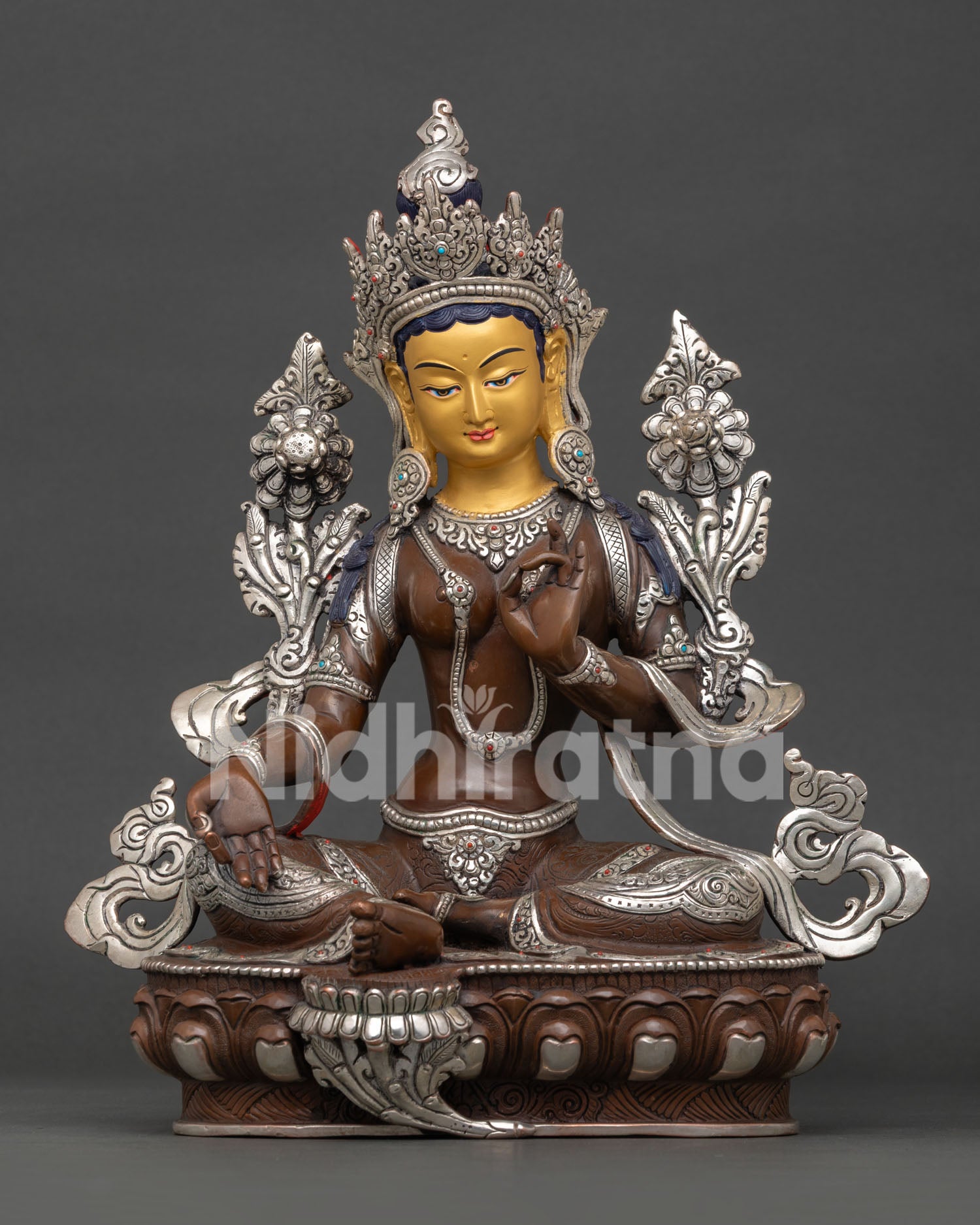 Green Tara Buddhist goddess sculpture seated on lotus throne with turquoise and coral stone adornments symbolizing healing and strength.