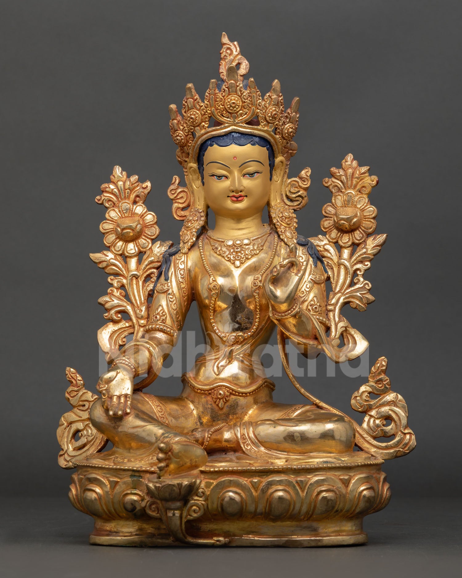 Green Tara Buddhist goddess statue seated in lalitasana posture, holding utpala flower, sitting in Varada Abhaya mudra.