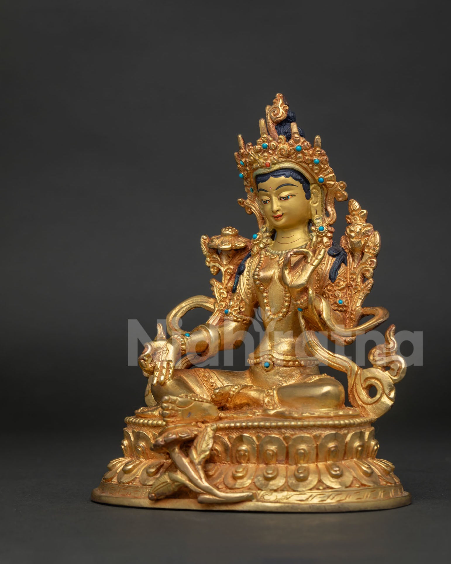Green Tara Buddhist statue seated on hand carved double lotus pedestal with vajra symbols.