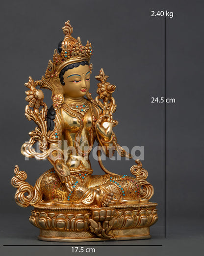 Green tara buddhist statue seated on lotus pedestal.