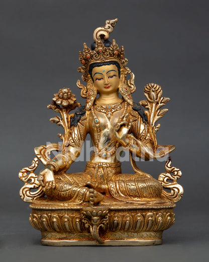 Green Tara Buddhist statue seated on lotus throne with extended right leg and lotus flower.