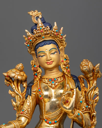 Green Tara Buddhist statue with gold painted face five jeweled crown and intricate sacred ornaments.