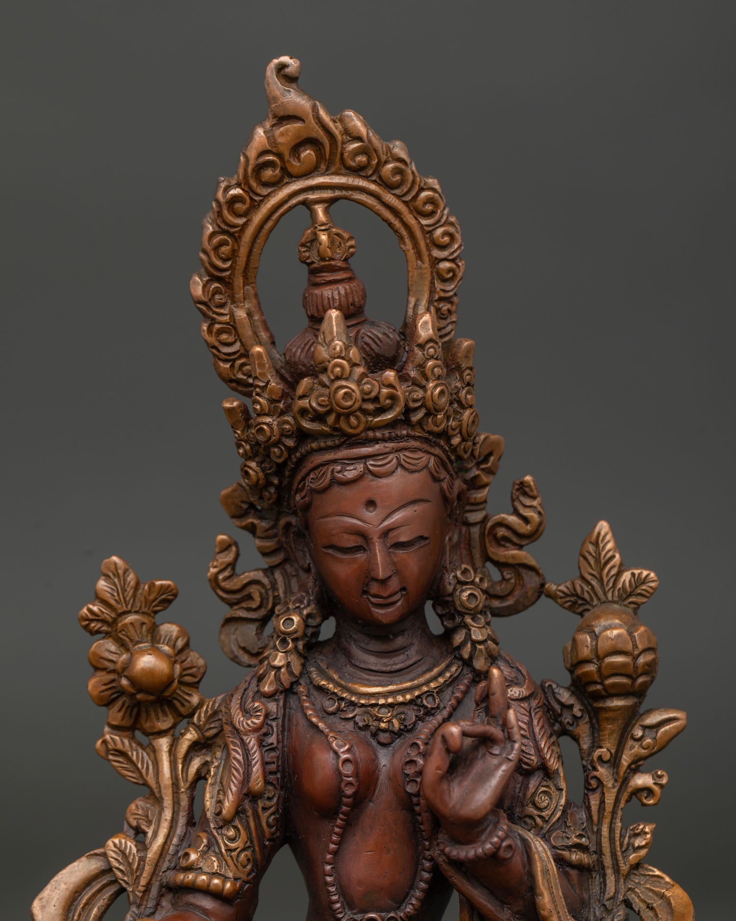 Green Tara copper statue holding blue utpala lotus with jeweled crown.